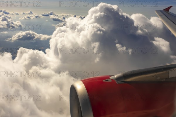 A colour landscape image looking out through airplane window showing land, cloud and sky