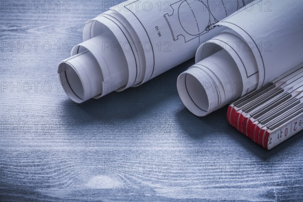Two rolls of blueprints and white wooden meter