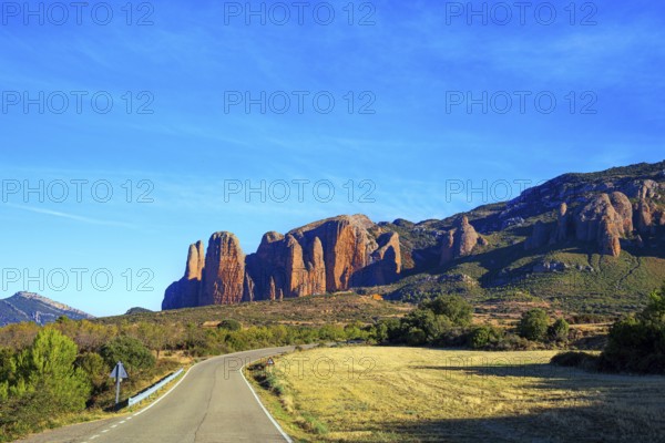 The magnificent Mallets of Riglos is a conglomerate of rock formations. Scenic paved highway. Romantic trip to Spain, Hoya de Huesca. The foothills of the Pyrenees. Sunny afternoon