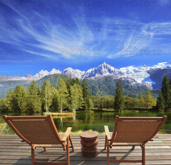 City park in the Alpine resort. Comfortable lounge chairs on wooden platform for rest and observation
