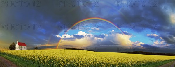 Panorama, chapel and rainbow over a rapeseed field