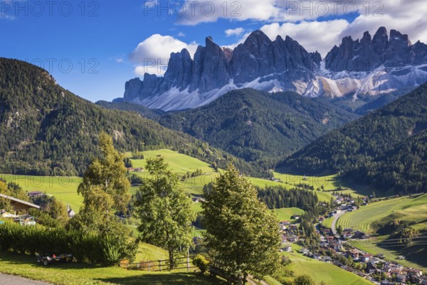 Dolomites, Val de Funes valley. Lovely autumn day. Picturesque mountains surround the green alpine meadows of the valley
