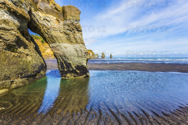 Coastal rock arches Three Sisters and Elephant on the Pacific coast. The concept of active and phototourism. New Zealand, North Island