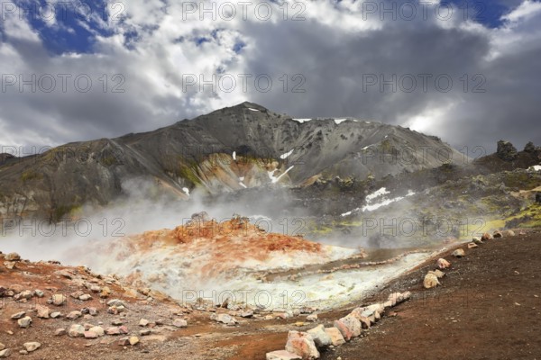 Rhyolite mountains smoldering underground heat. In the hollows lie unmelted snow patches from last year