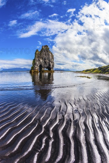 Ocean tide at sunset. The north coast of Iceland. Rock Hvitserkur on the sea beach in the form of a huge elephant. The concept of extreme northern tourism