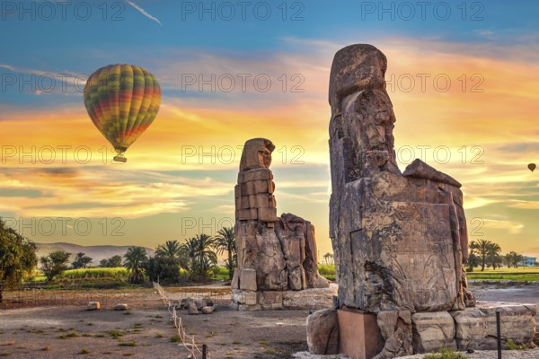 Hot air balloons and Colossus of Memnon in Luxor at sunrise, Egypt