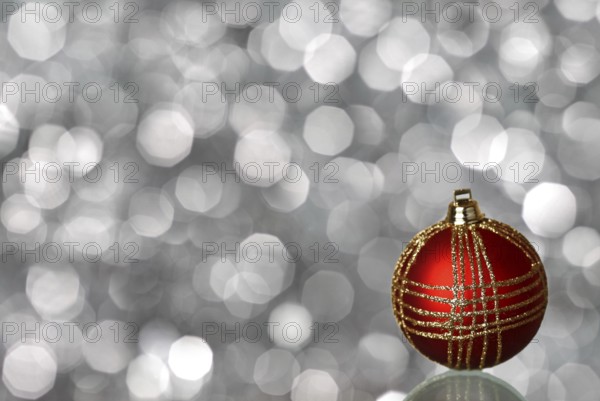 Red Christmas ball on silver blurred background