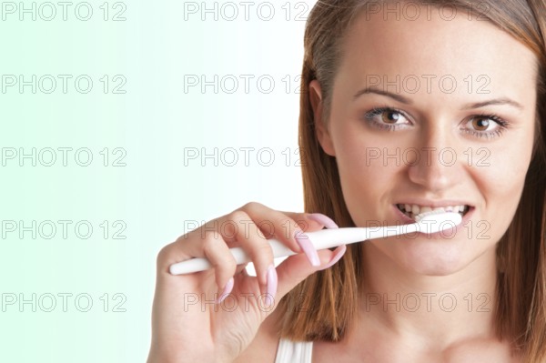 Closeup of young woman with a tooth brush on her hands, about to brush her teeth