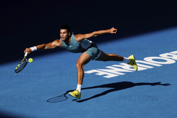 MELBOURNE, AUSTRALIA - JANUARY 19: Carlos Alcaraz of Spain hits a forehand to Jack Draper of Great Britain on day eight of the 2025 Australian Open at Melbourne Park on January 19, 2025 in Melbourne, Australia