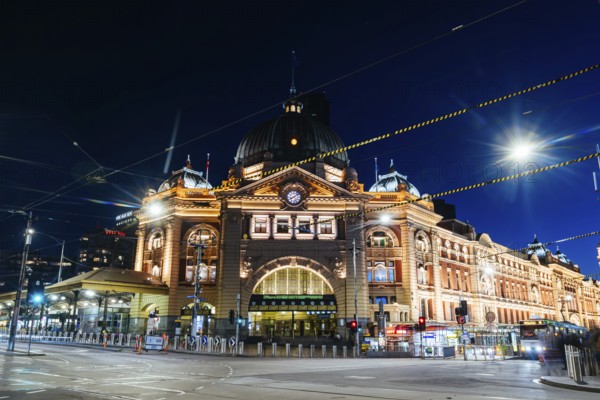 MELBOURNE, AUSTRALIA - OCTOBER 10, 2024: Melbourne's Flinders Station at dusk and rush hour with traffic and pedestrians on October 10th, 2024