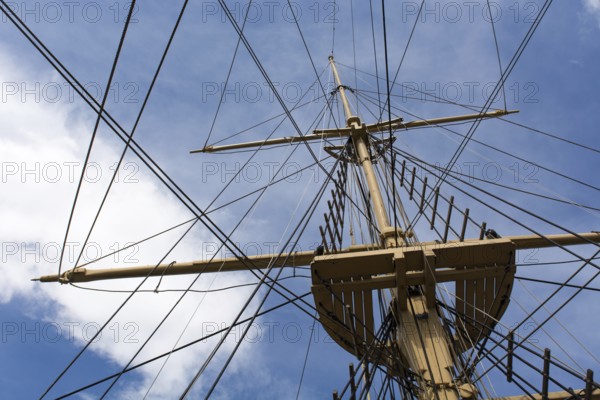 Mast and rigging of a big old sailing ship in front of a blue sky