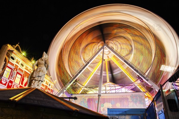 Stone sculpture, miner's fountain in front of Ferris wheel, long exposure, night shot, Leoben, Styria, Austria