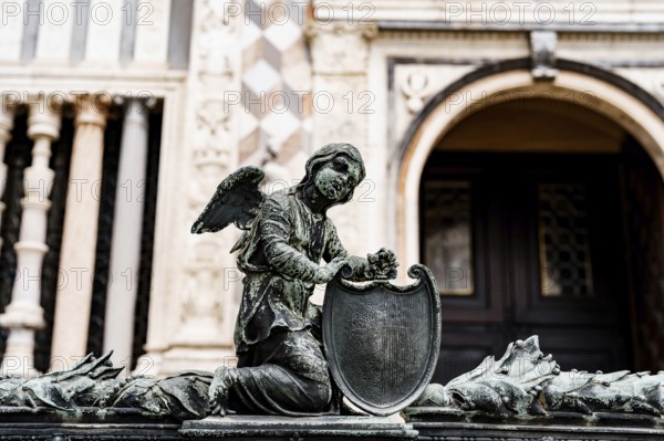 Statue of an angel with a shield near the entrance to the Colleoni Chapel. Bergamo, Italy.