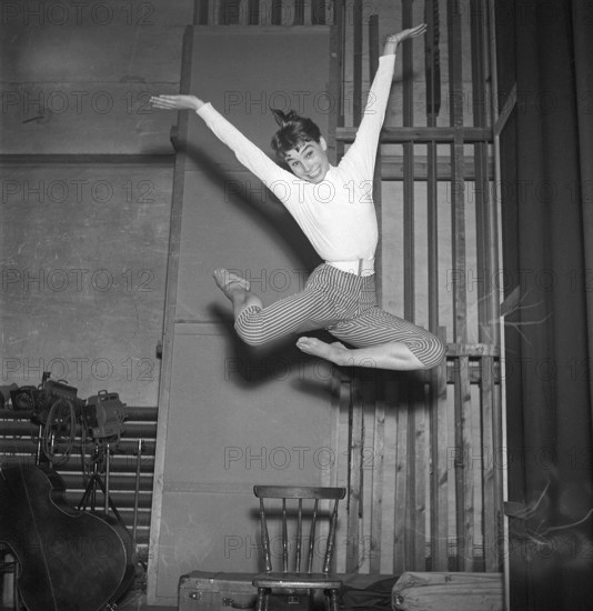 In the 1950s. An unknown young woman is pictured in the moment when being highest in the air having jumped off the chair. Besides the height of the jump she even manages to smile, keep eyecontact with the photographer and position her arms and legs in an artistic pose. Sweden 1954 Kristoffersson ref BX38-7