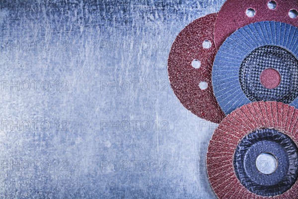Grinding discs abrasive flap wheels on scratched metallic background copy space
