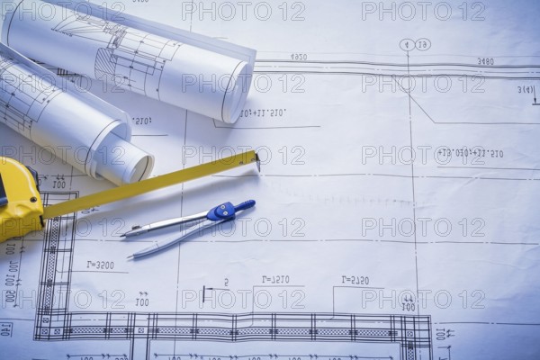 Two rolled blueprints tapeline compass with copyspace construction concept