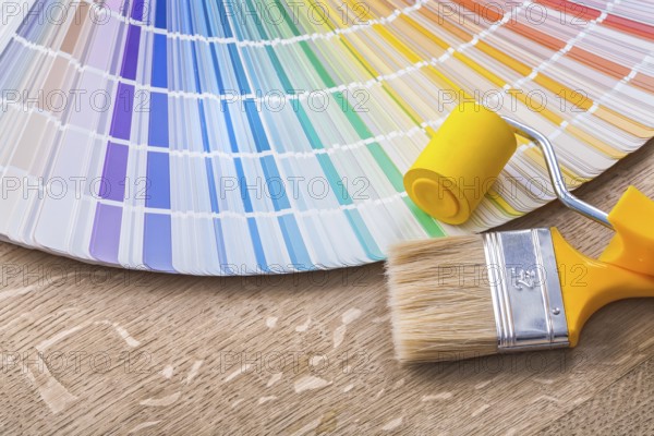 Paint brush roller and color palette on wood board