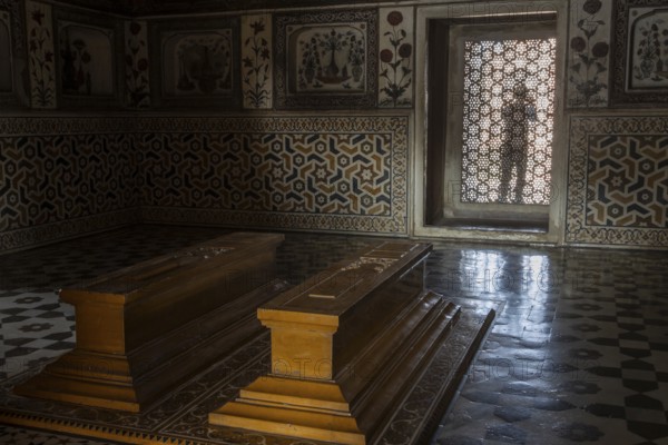 Tomb of I'timad-ud-Daulah, Mirza Ghiyas Beg, a high official in the Mughal Empire. Surrounded by charbag, the Indo-Persian style garden, the white marble mausoleum decorated with pietra dura stone inlay technic is often called Baby Taj or Bachcha Taj. It is a fine example of the Mughal architecture, and was one of the inspirations for the design of the Taj Mahal. Interior with two sarcophagi and a jali, a carved latticed stone screen in the window. Agra, Uttar Pradesh, India