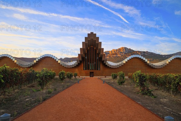 The magnificent modern architecture of Bodegas Ysios. Bright flaming colors of the sunset. Journey to the warm Spanish autumn