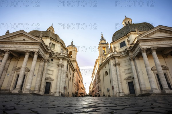 Two churches flank a street at dawn Piazza del Popolo, Rome