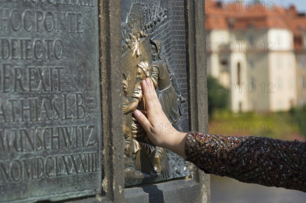 Place your hand on a bronze plate for good luck