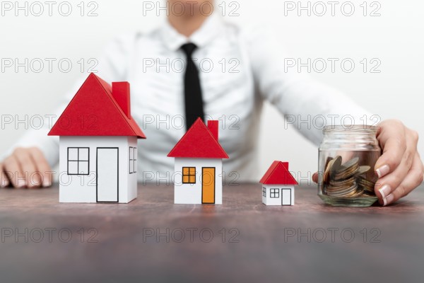 Save for home. Saving money for house and real estate. Woman hand protecting on stack coins and house model on table
