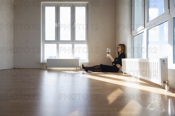 Beautiful elegant girl sits on the floor in a large light room with stained glass windows