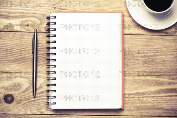 White blank notepad with cup of coffee on wooden table