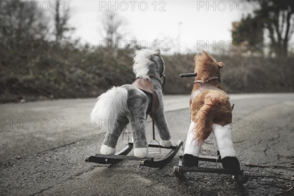Abandoned rocking horses on the road. Concept of abandonment, loneliness, the end of childhood