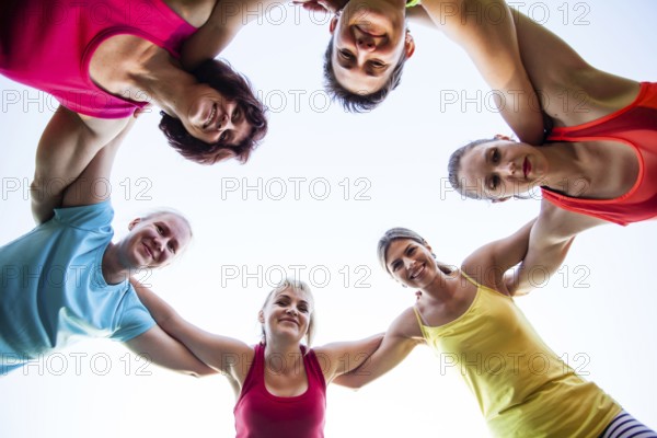 Close-up of fit girls putting hands on top of each other as symbol of successful collaboration