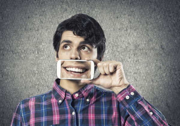 Young man holding smartphone with smile on screen