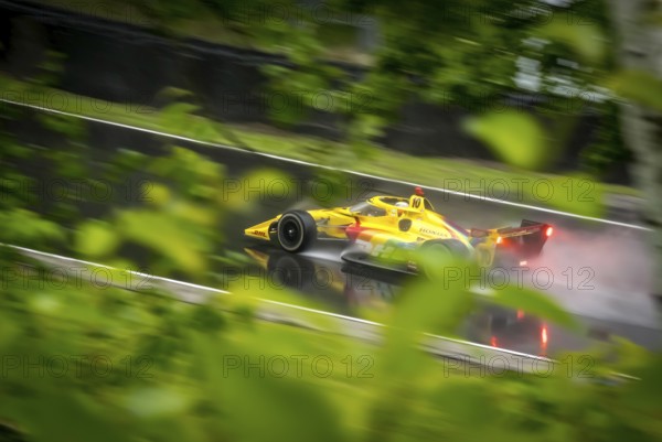 ALEX PALOU (10) of Barcelona, Spain comes through turn 12 (Canada Corner) during a wet practice session for the XPEL Grand Prix at Road America in Elkhart Lake, WI