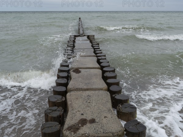A wooden breakwater extends into the sea, surrounded by water and waves, ahrenshoop, zingst, germany