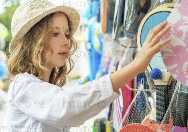 Little girl is choosing table tennis racket for vacations