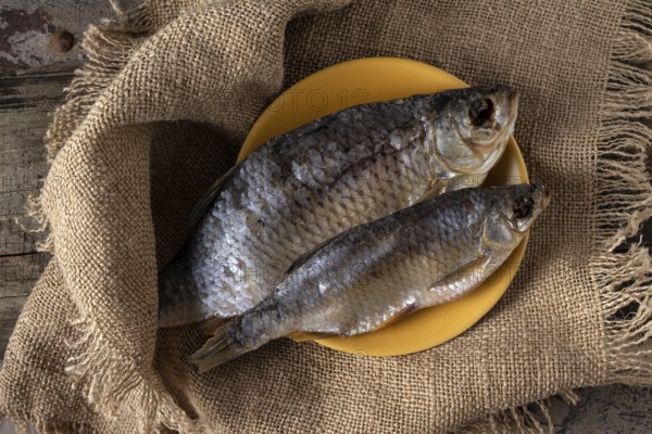 Two dried fish - rudd lie on a canvas napkin