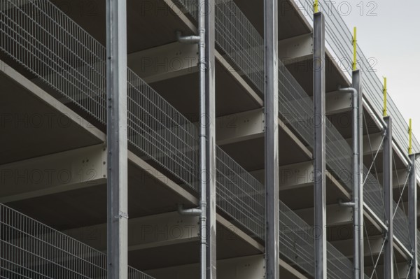 Modern parking garage levels with metal grid railing and support structure