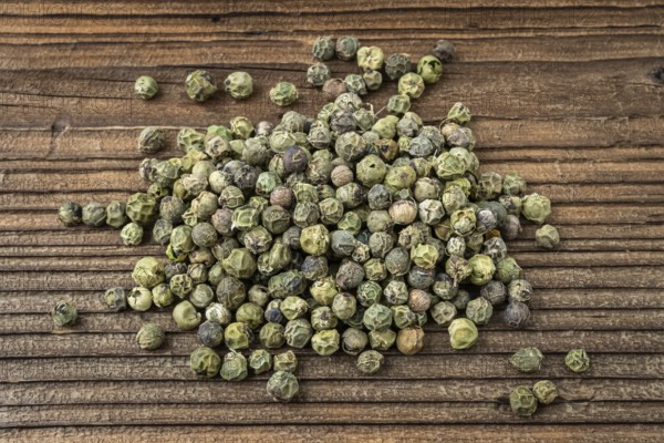 Dried spices green pepper. Peppercorn on a wooden board