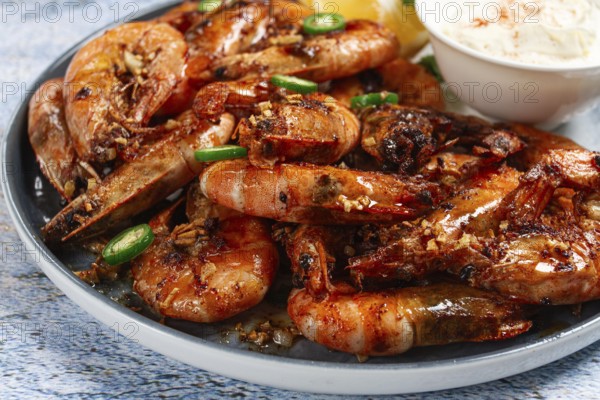 Grilled shrimps served with hot sauce and slices of fresh lemon, homemade, no people