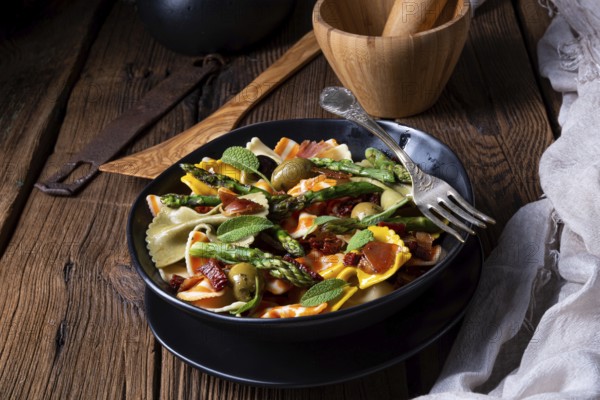 Pasta salad with green asparagus, olives and Parma ham