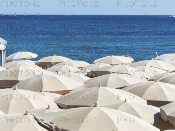 Many sunshades on the beach, symbolic photo for holidays, mass tourism, sunburn Austria