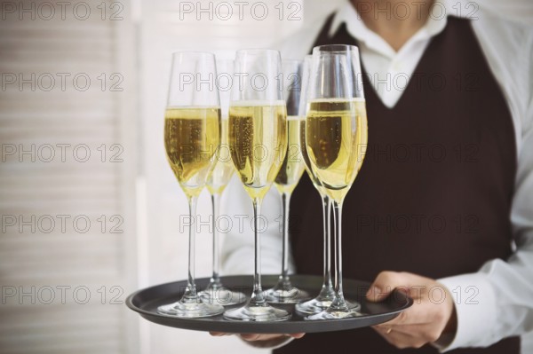 Professional male waiter in uniform serving champagne. DOF. Natural light. Photo in motion