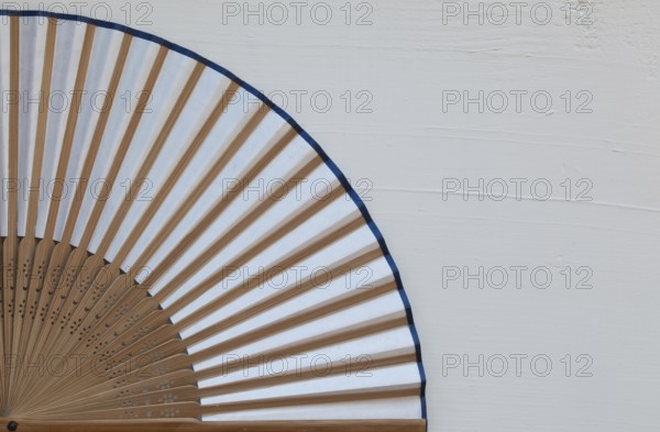 Typical Japanese hand fan made on the wooden white table