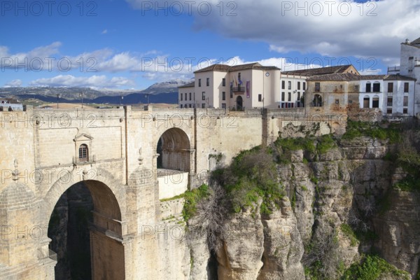 View of buildings in new town from other side of the 18th century bridge over the 300 ft Tajo Gorge in Ronda Spain