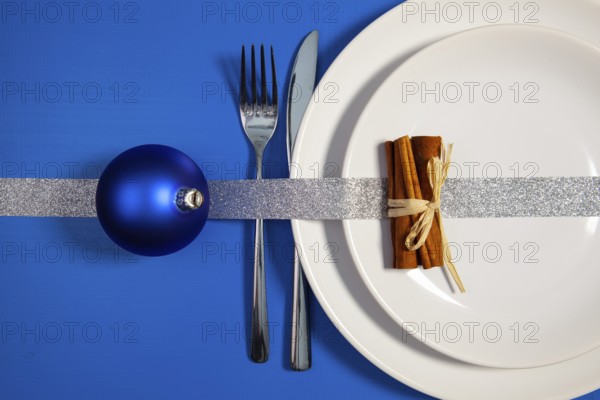 Two white plates and Christmas decoration on the blue wooden table.Top view.Flat Lay Image