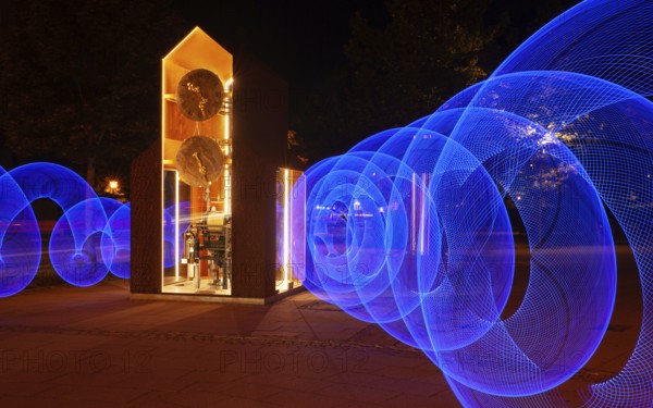 Blue light circles created with LED lights encircle an artistic large clock, Lightpaniting, Mindelheim, Unterallgäu, Bavaria, Germany