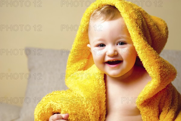Girl after bathing, sitting in yellow bathrobe