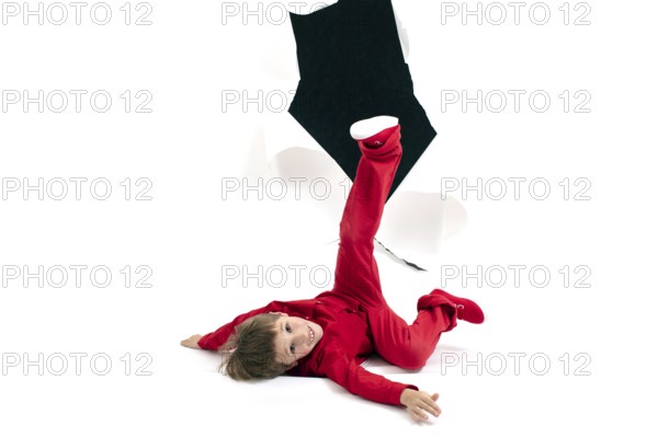 A child from a hole in the paper. Boy shows cardboard. Falling out of the billboard