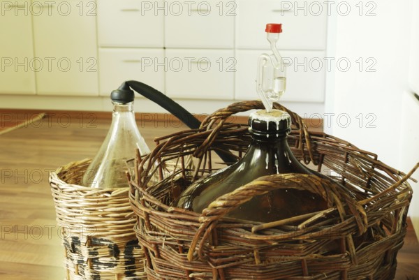 Bottles of homemade wine in wicker baskets