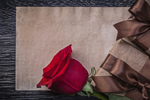 Vintage paper red expanded rose wrapped giftboxes on wooden board