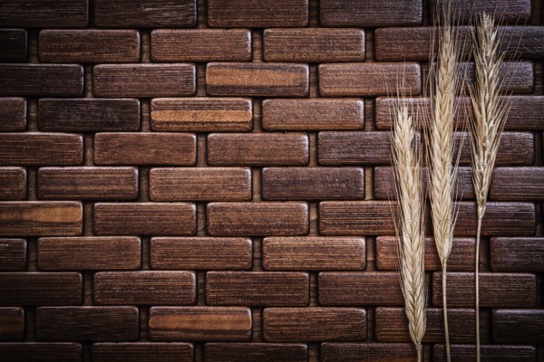 Wheat and rye ears on wooden backcloth close up view